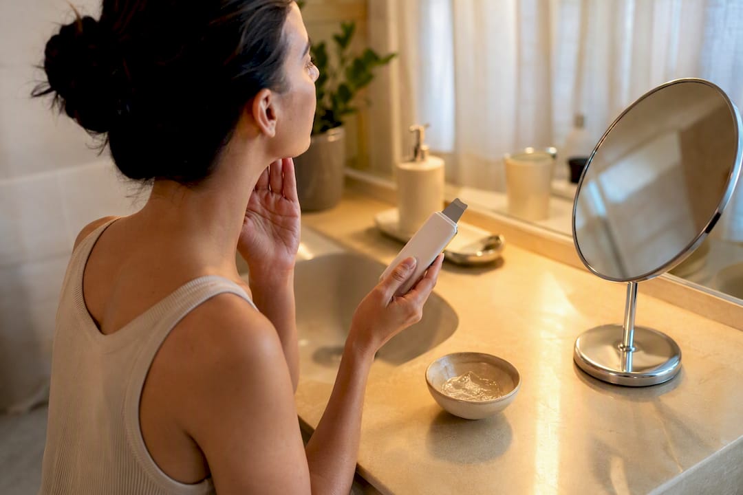 Mains tenant un appareil de soin du visage avec du gel
