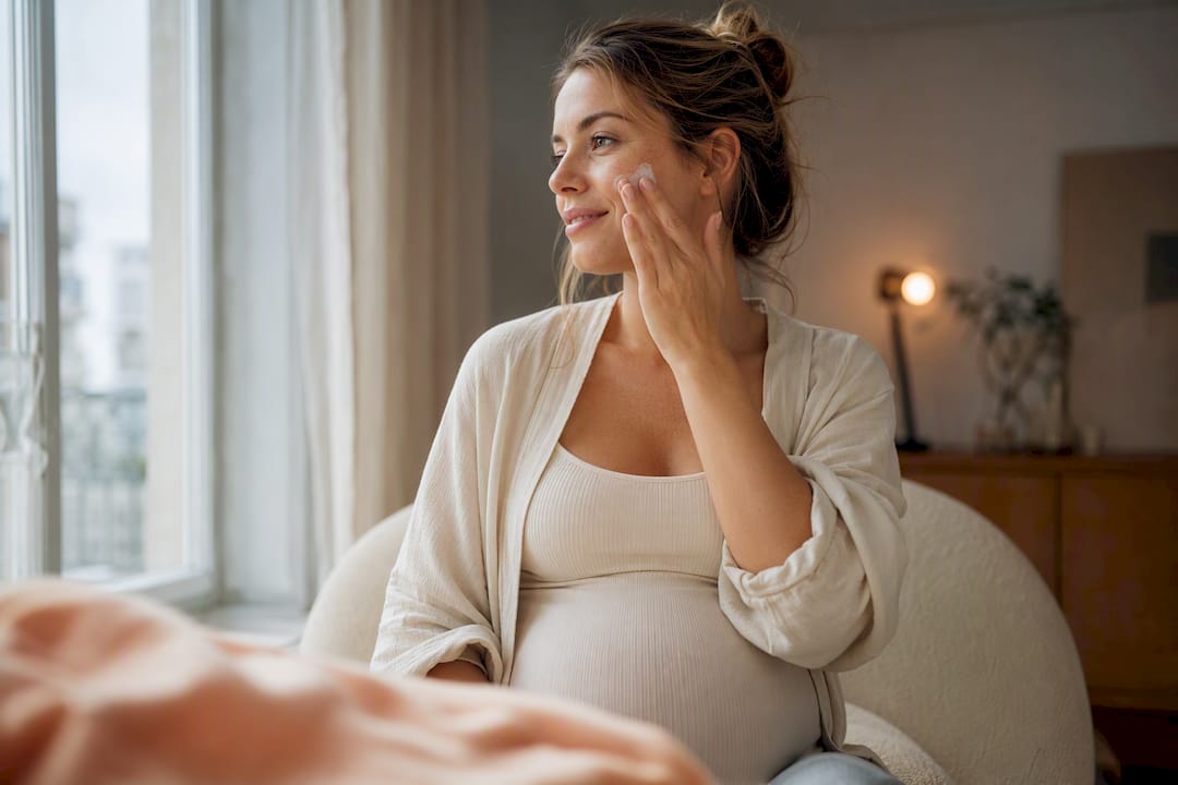Femme enceinte en train d'appliquer un soin du visage